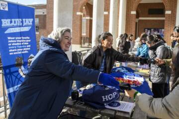 Students handing out gloves on Blue Jay Tuesday